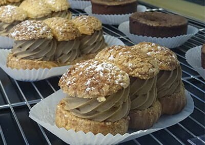 Plusieurs desserts choux café dans la vitrine du restaurant "Les Délices du Cotentin" à Sainte mere église.