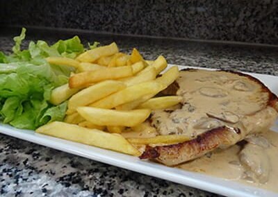 Assiette d'une cote de porc avec sa sauce normande du restaurant les "délices du Cotentin" à Sainte-mère-église