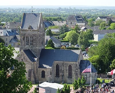 l'église de Sainte Mère vue d'en haut, avec la foule, pendant les commémorations du débarquement.