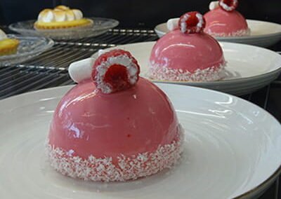 Gateau rose en forme de dome avec une framboise, du restaurant Les Délices du Cotentin" à Sainte mère église.