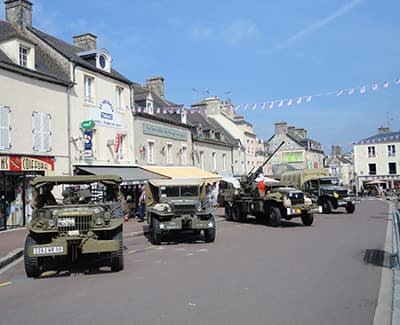 4 jeeps anciennes dans la rue principale de Sainte Mère.