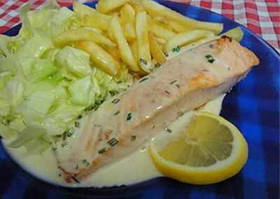 Saumon avec sauce , frites et salade dans une assiette bleue du restaurant "Les Délices du Cotentin" à Sainte mère église.