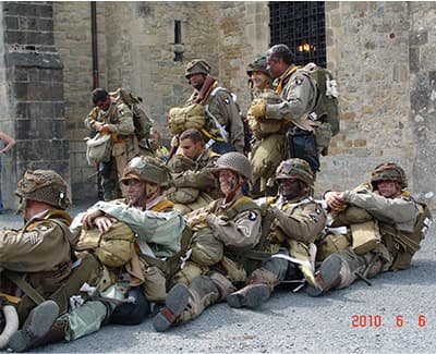 Soldats assis et chantant devant l'église de Sainte mère.